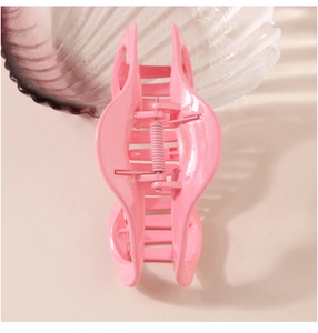 Detailed top view of a large pink hair claw clip showing durable teeth and metal spring