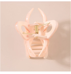 Macro detail of the hollow butterfly hair claw clip with its durable golden metal spring