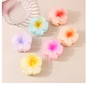 Set of 6 matte gradient flower hair claws in pastel colors shown on a beige surface