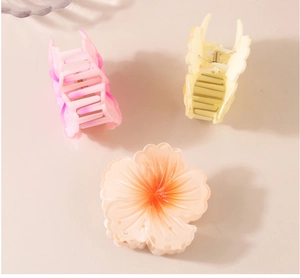 Detailed view of three gradient floral hair claws in pink, beige and purple resin finish