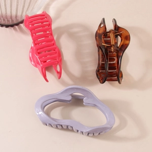 Three large matte hair claws in pink, tortoise, and purple displayed at a 45-degree angle