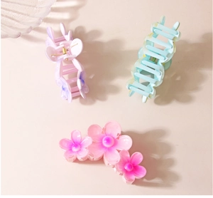 Détail des pinces à cheveux en forme de fleurs roses et accessoires en résine pastel