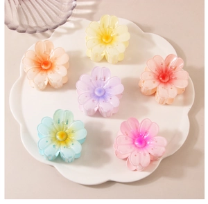 Set of six colorful jelly flower hair claws in pastel summer shades on a white plate