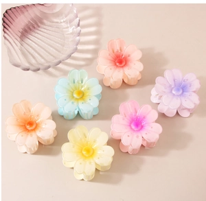 Flat lay of colorful resin flower hair claws in pink, blue, yellow and purple hues