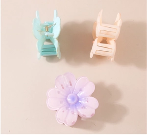 Close-up of translucent pastel flower hair claws in pink, blue, and purple gradients