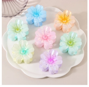 Draufsicht auf sieben bunte Blüten-Haarklammern in einer weißen floralen Dekoschale