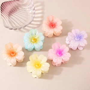 Set of six colorful floral hair claws with gradient jelly texture on a cream background
