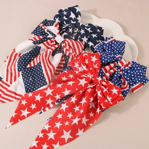 Close-up of American flag bow hair clips with stars and stripes ribbons in a decorative dish