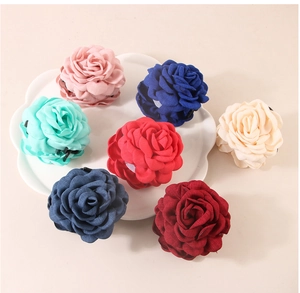 Close-up of fabric rose flower claw clips in seven vibrant colors for elegant styling