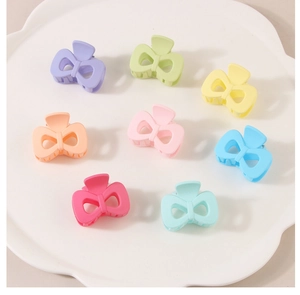 Set of 8 colorful matte butterfly hair clips in macaron tones on a white tray