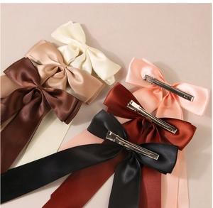 Detail view of colorful satin ribbon bow hair clips with metal alligator clips and long streamers