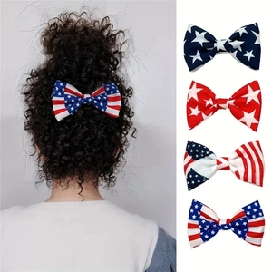 Detail of four American flag pattern hair bow clips with stars and stripes on hair and flat lay