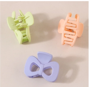 Three-piece hair clip set in pastel green, orange, and lavender purple with matte finish
