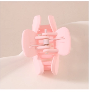 Close-up of pink matte hair claw clip showing durable metal spring and smooth texture