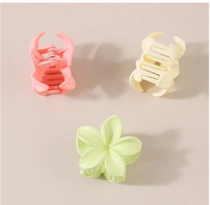 Drei Haarklammern in Pastellfarben wie Rosa, Gelb und Grün im Blumen-Design