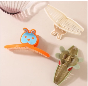 Détail de pinces à cheveux en plastique avec motifs de lapin et formes de fleurs