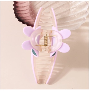 Vue détaillée d'une pince à cheveux lavande mate avec ressort doré et design pétale de fleur