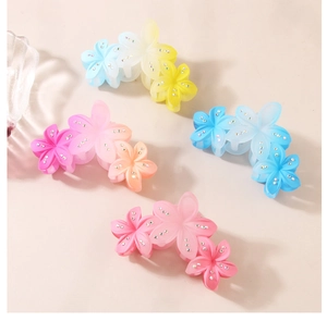 Detail of floral hair claws with gradient colors and sparkling rhinestone accents