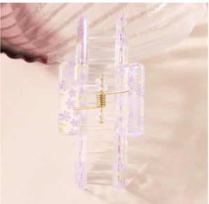 Detail of transparent square hair claw clip with purple floral print and metal spring