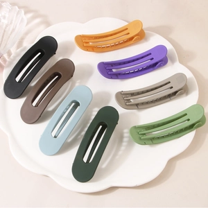 Lot de 8 pinces à cheveux mates de 11cm aux couleurs variées sur une assiette blanche
