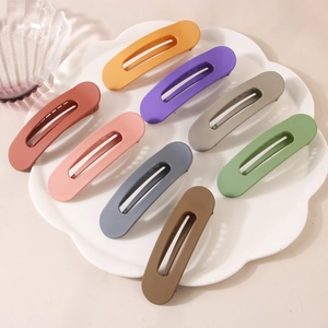 Lot de 8 barrettes à cheveux mates de 11cm aux couleurs variées sur une assiette blanche