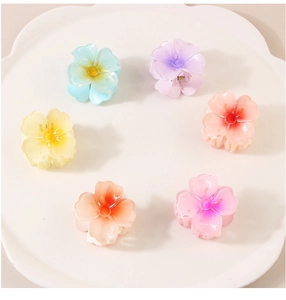 Detailed set of 6 colorful acrylic flower hair clips on a white petal tray