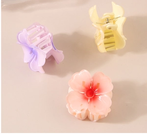 Detailed close-up of three colorful resin flower hair clips in pastel shades