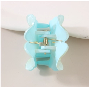 Detail view of the light blue translucent flower hair claw clip with golden spring mechanism