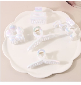 Ensemble de cinq pinces à cheveux en acrylique nacré aux motifs géométriques