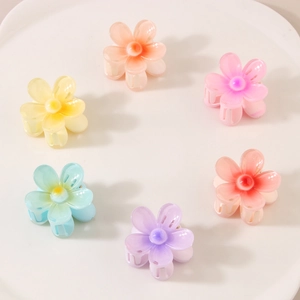 Lot de 6 pinces à cheveux fleurs colorées aux tons pastels sur une assiette blanche