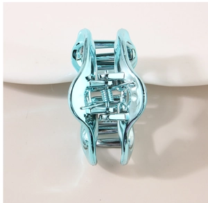 Dettaglio di un fermaglio per capelli a nuvola blu metallizzato su base bianca