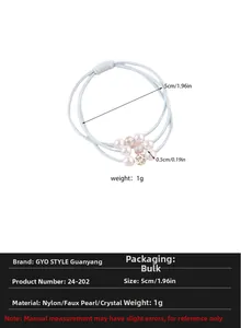 Detail view of elastic blue hair tie featuring pearls and sparkling rhinestones