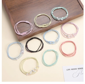 Detailed set of colorful elastic hair bands with pearls and rhinestones on a tray