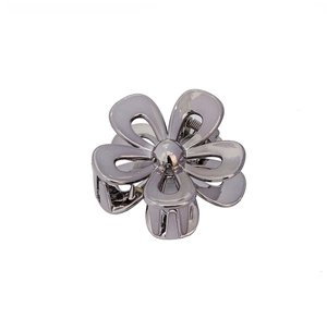 Close-up of a gun-black 3D flower hair claw clip with hollow petals and polished alloy finish