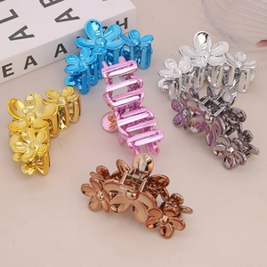 Lot de sept pinces à cheveux fleurs élégantes aux finitions métalliques variées sur beige