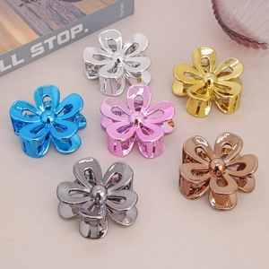 Set of six metallic flower hair claws in silver gold and rose gold on a pink background