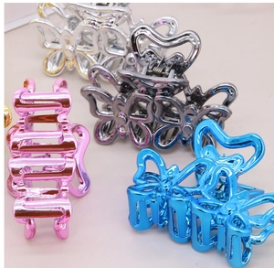 Vue détaillée de pinces à cheveux papillon en argent, gris, bleu et rose à finition métallique