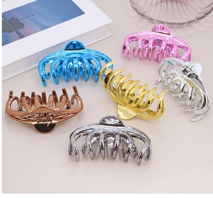 Detail of high-gloss metallic hair claws in multiple colors including gold and rose gold