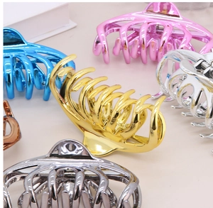 Detailed macro view of large hollow geometric hair claws in various vibrant metallic finishes