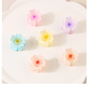 Gros plan de six mini-pinces à cheveux en résine mate en forme de fleurs colorées