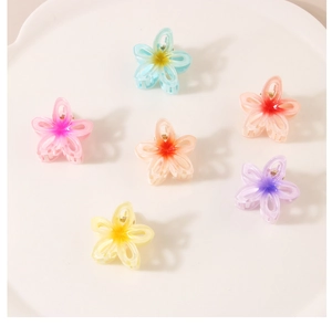 Set of six colorful gradient flower hair claws in pastel resin on a white tray