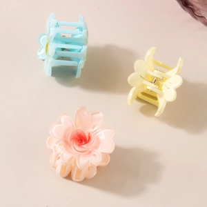Trois pinces à cheveux fleurs en rose, bleu et jaune avec design de pétales en cœur