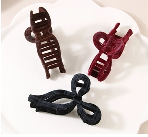 Detail of plaid flocked shark hair clips in brown, burgundy, and navy blue patterns