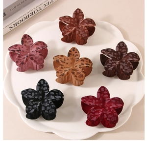 Dettaglio di sei mollette per capelli a forma di fiore con stampa leopardata autunnale