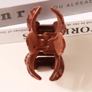 Pinza per capelli marrone con motivo a cuore su un libro per un'acconciatura elegante