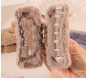 Gros plan d'une grande pince à cheveux en peluche marron clair avec ressort métallique
