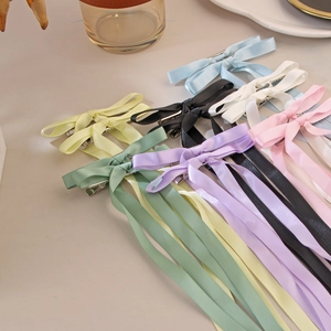 Close-up of colorful satin ribbon bow hair clips with long streamers in various pastel colors