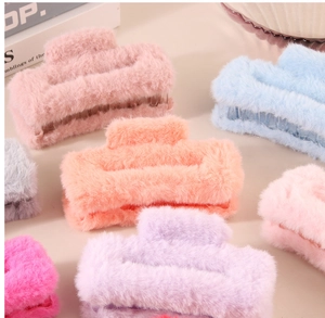 Gros plan sur des pinces à cheveux en peluche douce aux couleurs pastel automne-hiver