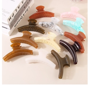 Macro shot of large acrylic shark hair clips in eleven varied colors and matte finishes