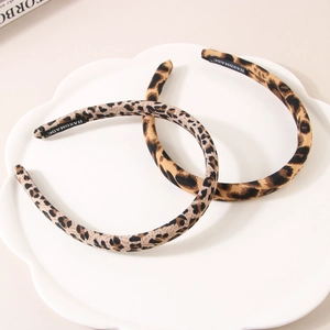 Two-pack of vintage leopard print fabric headbands with handmade labels on a white tray